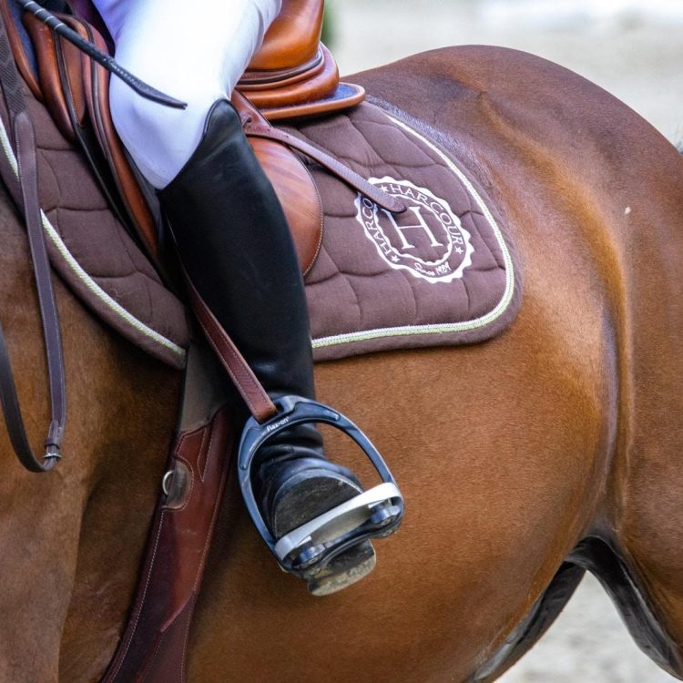 person in white cowboy hat riding brown horse during daytime